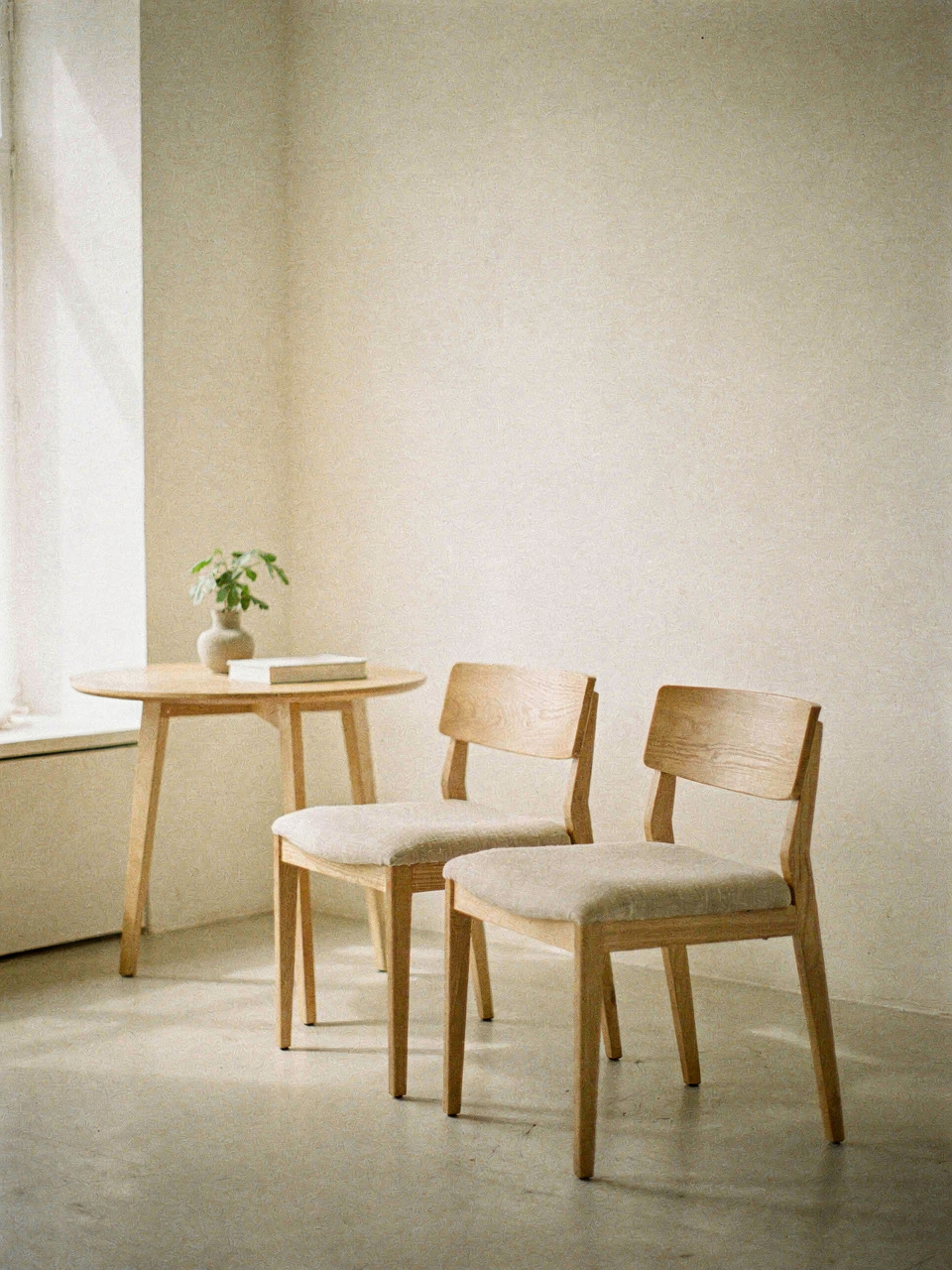 Par de cadeiras de madeira clara com assento de linho em sala minimalista